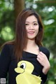 A woman in a black sweater with a yellow duck on it.