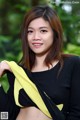 A woman in a black top and yellow scarf posing for a picture.