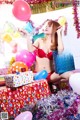 A woman in a red bikini sitting on top of a pile of presents.