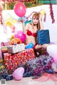 A woman in a red bikini sitting on a pile of presents.