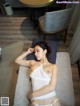 A woman in a white lingerie laying on a bed.