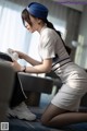 A woman in a white uniform is cleaning a suitcase.