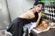 A woman in a black dress sitting at a kitchen counter.