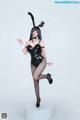 A woman in a black bunny costume posing for a picture.