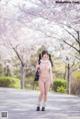 A woman in a pink bikini walking down a sidewalk.