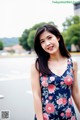 A woman in a floral dress posing for a picture.