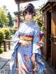 A woman in a blue kimono standing in front of a building.