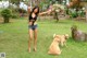 A woman standing in the grass with two dogs.