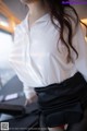 a woman in a white shirt and black skirt