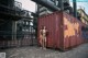 A couple of naked women standing next to a shipping container.