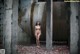 A naked woman standing in an abandoned building.