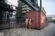 A couple of naked women standing next to a shipping container.