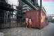 A couple of naked women standing next to a shipping container.