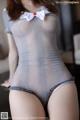 A woman in a gray bodysuit with a white bow tie.