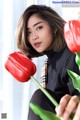 A woman holding a bunch of red tulips in her hand.