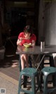 A woman sitting at a table eating a bowl of food.