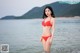 A woman in a red bikini standing in the water.