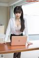 A woman sitting at a desk with a laptop computer.