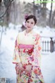 A woman in a kimono standing in the snow.