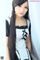 A woman with long black hair wearing a maid outfit.