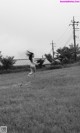 A naked woman running through a field of grass.