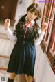 A woman in a school uniform holding a stick.