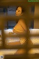 A woman in a white lingerie sitting on a bed.