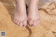 A close up of a woman's feet on a sandy beach.