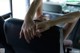 A woman sitting in the back seat of a car with her hands on the seat.