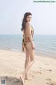 A woman in a bathing suit standing on a beach.