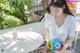 A woman sitting at a table with a toy fish.