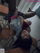 A woman laying on top of a desk in a classroom.