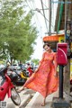 A woman in a pink dress standing next to a red post box.