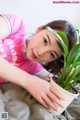 A woman laying on a bed next to a potted plant.