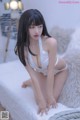 a woman in a white lingerie sitting on a bed