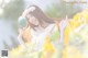 A woman in a white dress standing in a field of yellow flowers.