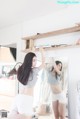 A woman standing in front of a mirror in a room.