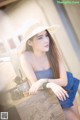 A woman in a straw hat sitting at a table.