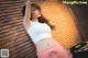 A woman leaning against a brick wall with a record player.