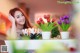 A woman sitting at a table with flowers in front of her.