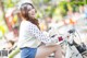 A woman sitting on top of a white bike.