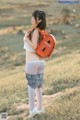 A woman with a backpack standing in a field.