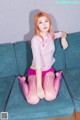 A woman sitting on a blue couch wearing pink stockings.