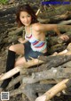 A woman sitting on top of a pile of logs.