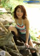 A woman sitting on top of a pile of logs.