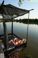 A woman in a red bikini laying on a dock.