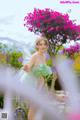 A woman in a fairy costume standing in a garden.