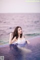 A woman in a white bathing suit sitting in a pool.