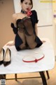 A woman sitting on top of a table next to a pair of shoes.