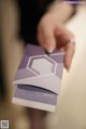 A person holding a purple business card in their hand.